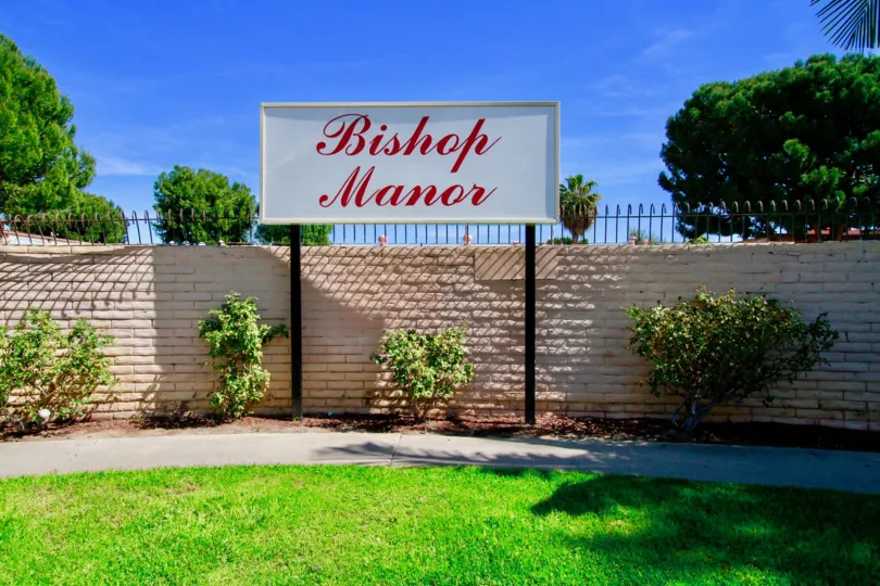 A cool day in the Bishop Manor with a sign and lawn.