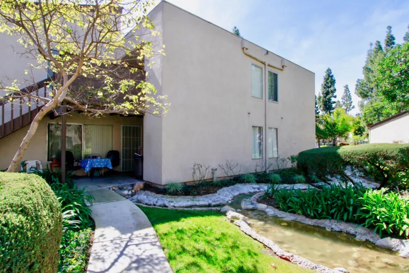 A white home of Cabrillo park with a sidewalk and bushes