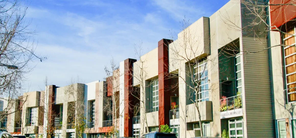 A line of buildings in City Place with trees on a sunny day