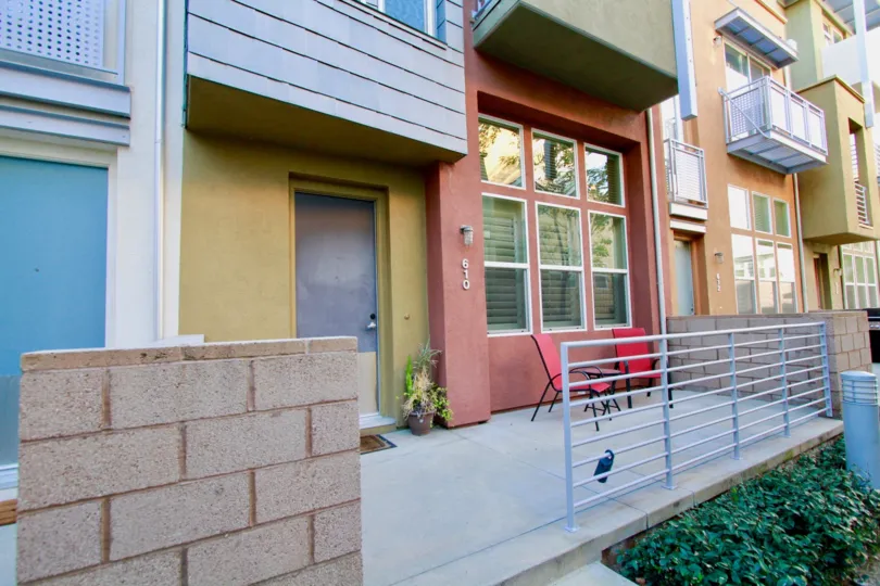 A entrance to multicolored building in City Place with deck chairs.