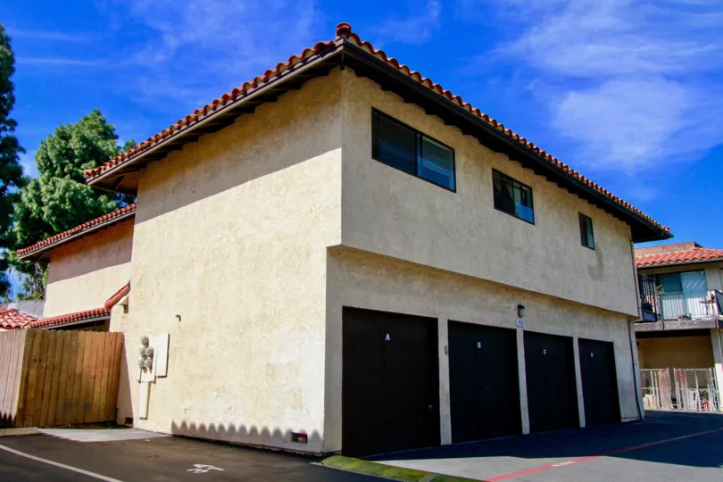 Four dark colored garage doors on a condo building at Corsican Village.
