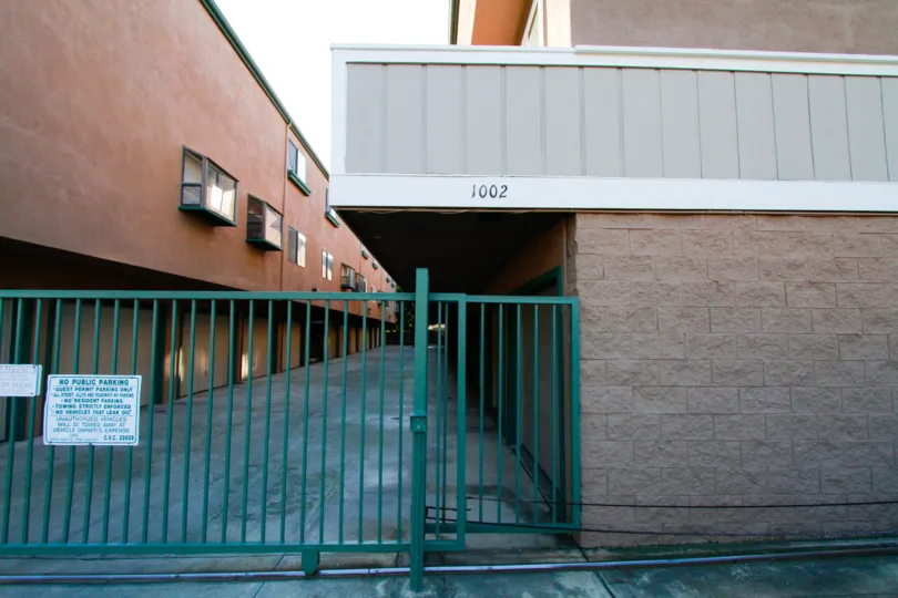 A white and green sign sits on a green gate at Emerald Terrace condos.