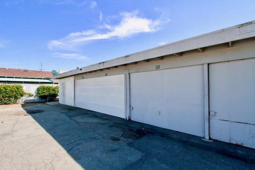 A morning in the Garden Villas with garage front under the blue sky.