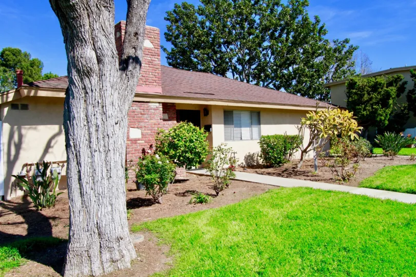 A home with the Hillview Regency with a tree and sidewalk.