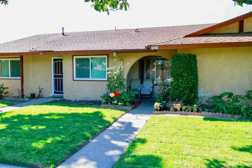 A home in the La Linda Villas with a sidewalk and patio chairs.