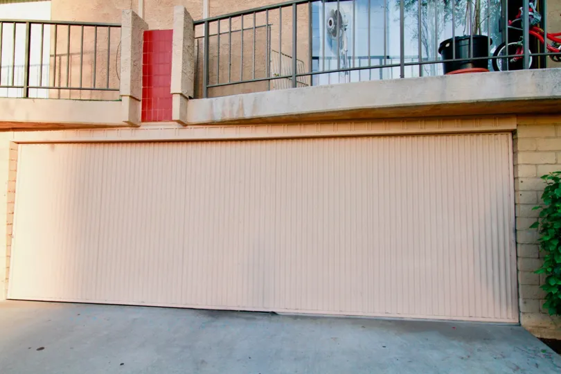 A view of a large garage door below a balcony in the La Plaza Real community