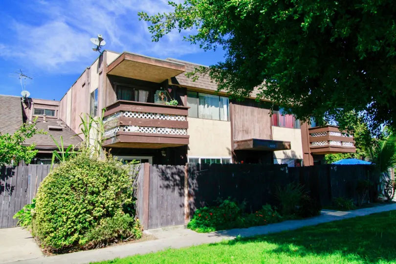A two story building of Newhope Garden with a wooden fence of a sunny day.
