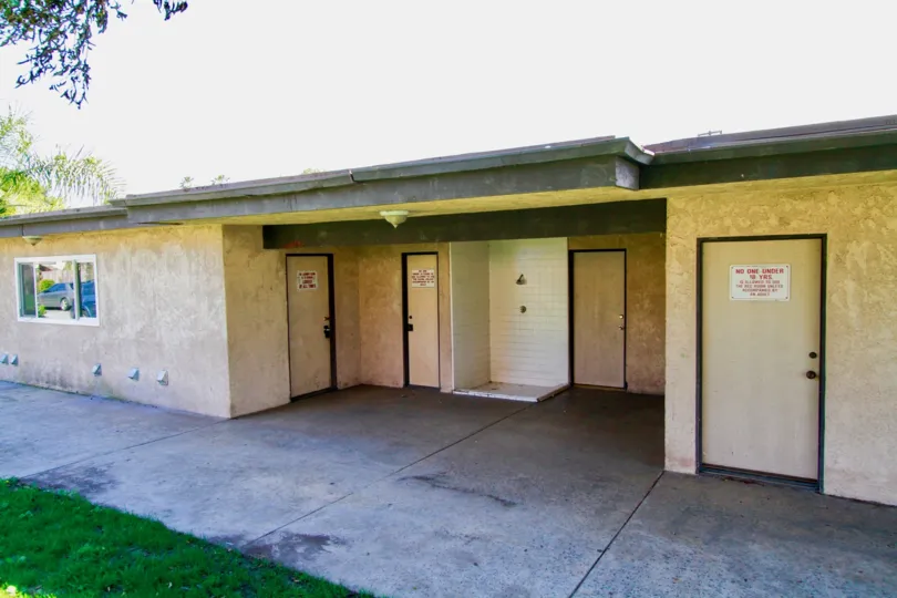 A building with multiple doors and a wide front yard in the Newhope Garden community