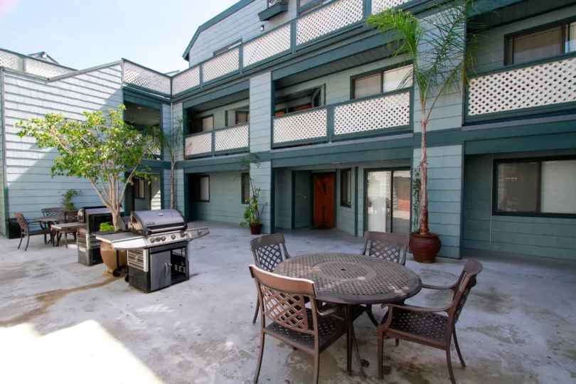 Dinning table and stove is present at center of the villa's in Pine vista with flower pots and plants