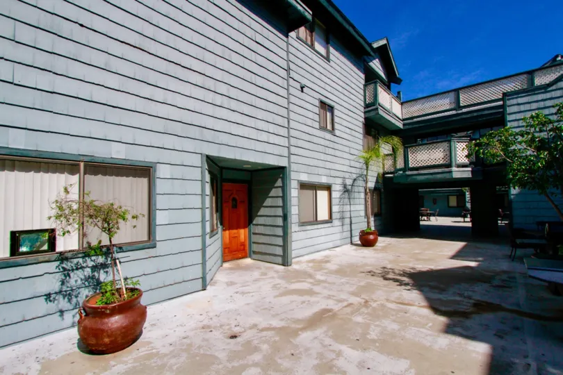 A cedar door entrance of a blue multi level housing area in Pine Vista community.