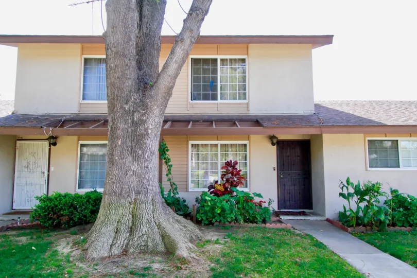 A frontal view of a mid size house with a garden in the Saddlebark park community
