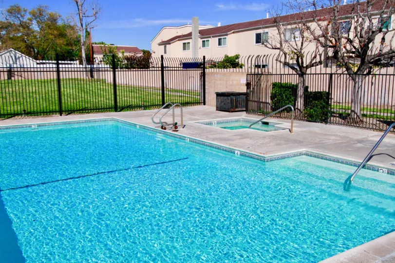 A sunny day in the Sandalwood Village with a swimming pool and building.