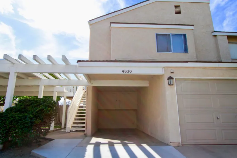A two story home in Sandalwood Village with a garage and staircase.