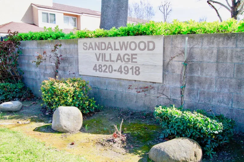 A bright day in the Sandalwood Village with a signage on the wall.