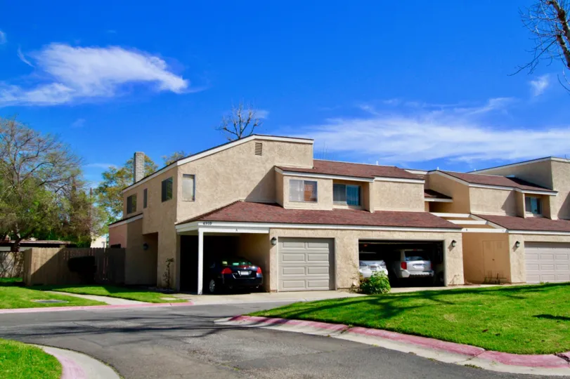 Sandalwood Village duplex with garages and fences on a sunny day.