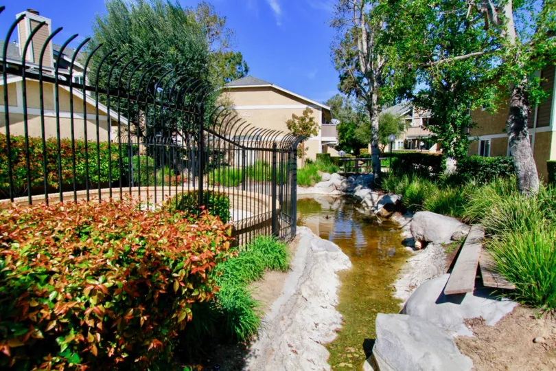 A great day in the Santiago Springs with a garden nearby some buildings.