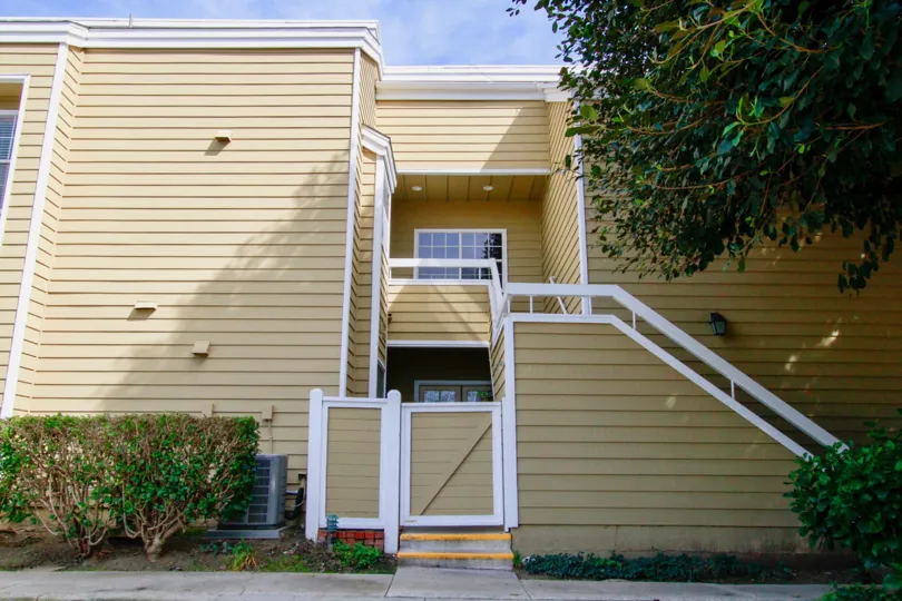 Outer View of a home in South Coast Springs Community with view of garden and stair case.