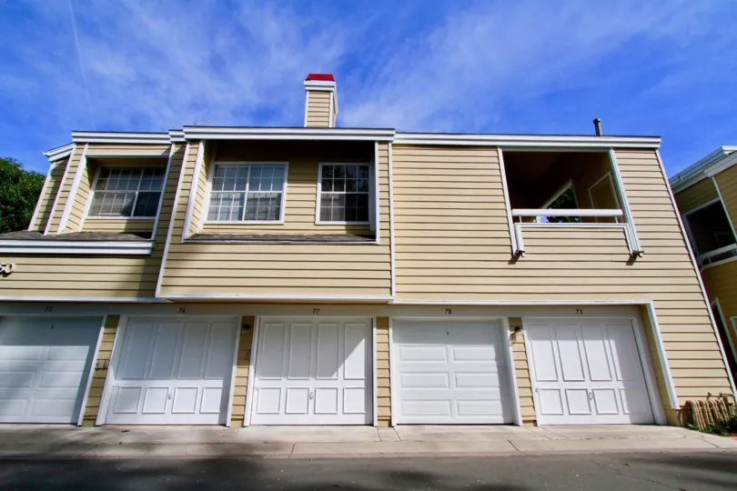 Multiple garage doors of a residence below large windows in the South coast springs community
