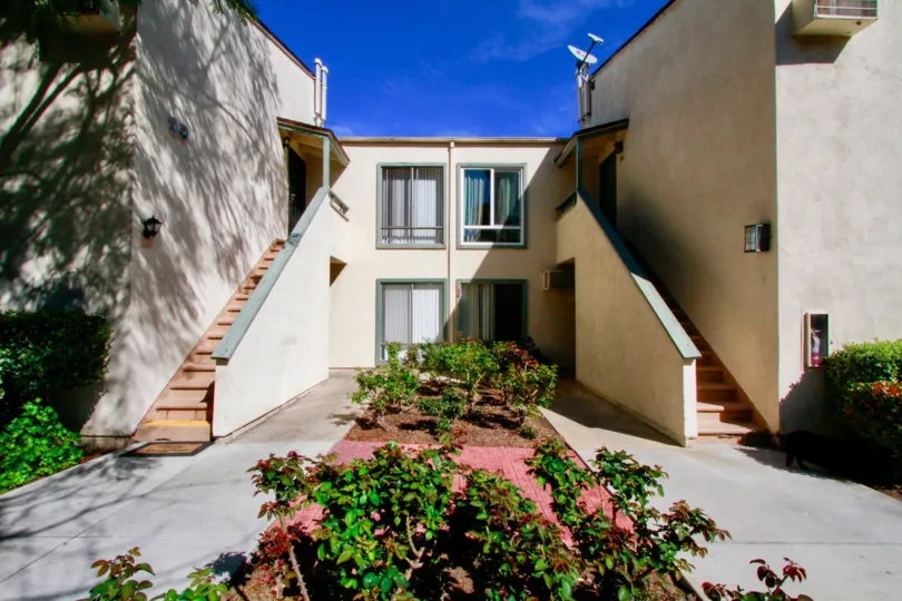 A bright day in the South Coast Terrace in front of the house with staircase.