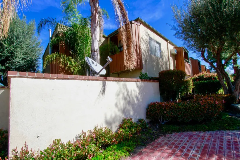 A beautiful white and red house in the South Coast Terrace with beautiful flowering plants, trees and shrubs.
