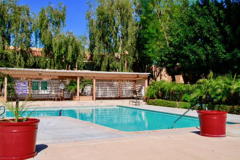 A lovely pool area surrounded by plants and trees inside South coast villas community