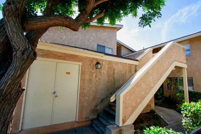 At sunny day, Villa in summer green has tree and give shadow near the stairs with bushes