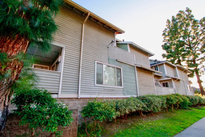 A side view of a lovely house surrounded by a garden with lawns in the Sunwood square community