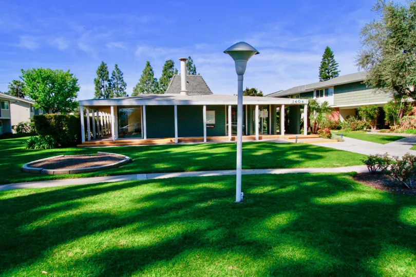 A lawn in the Tennessean with walking paths and street lamps on a sunny day.
