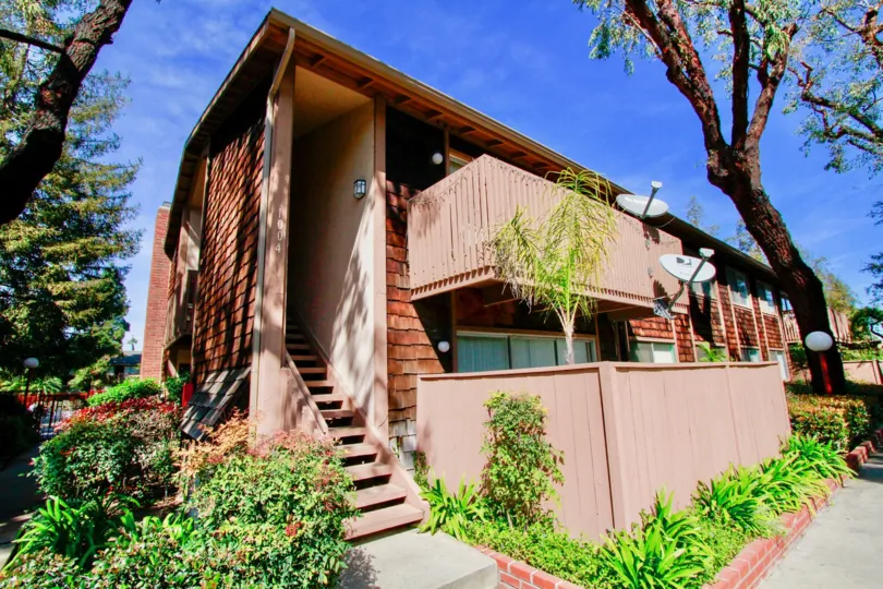 A small row house with a small compound and a staircase in the side in The Redwoods community