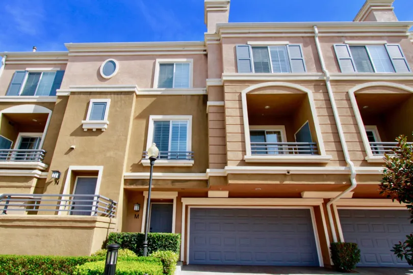 A multi storyed bunglow with multiple balconies overlooking the road and garden in Vantage community
