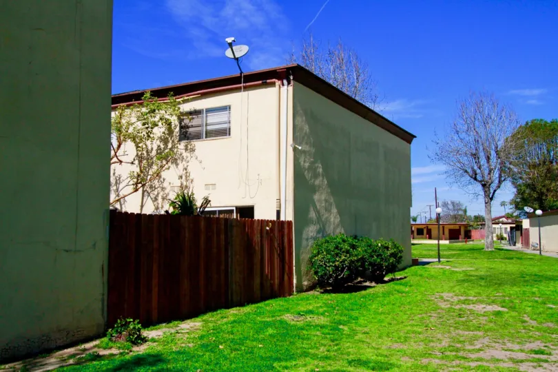 at the roof of the house in village gardens dish antenna is connected and with lawn and bushes with trees