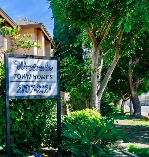 Address of Westvale Townhomes is marked as board and fixed near the cutting bushes and plants