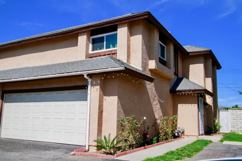 A two story home in the Westvale Townhomes with a garage and Christmas lights.
