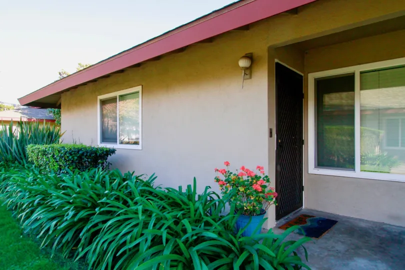 A door to a home in Westwood condos with plants and flowers.
