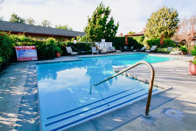 A clear day in the Westwood Condos with a swimming pool and trees.