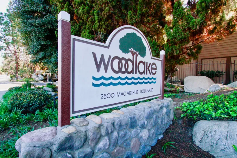 A cool day in the Woodlake with a sign in front of the tree.