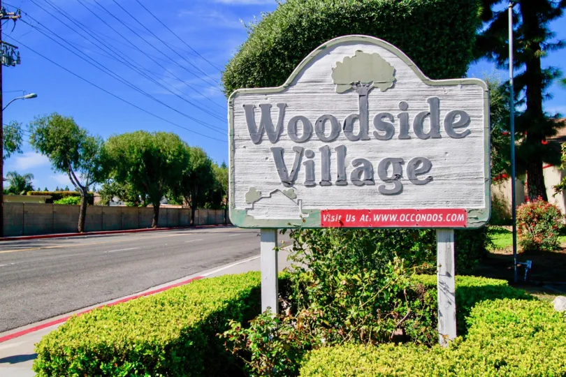 The woodside village board located at left side and a parallel road also there.