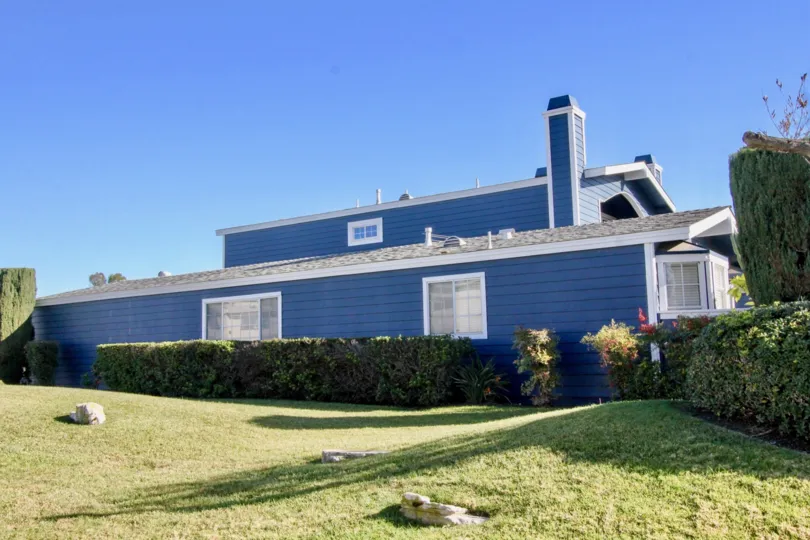 THE BLUE COLOR HOUSE IN THE BELL COVE WITH THE LAWN, PLANTS