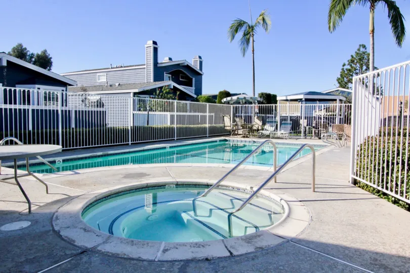A housing community with a sparse area and with a swimming pool surrounded by trees
