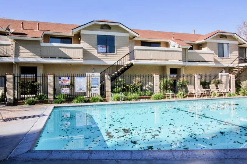 A large swimming pool in the Crosspointe Village with a building.