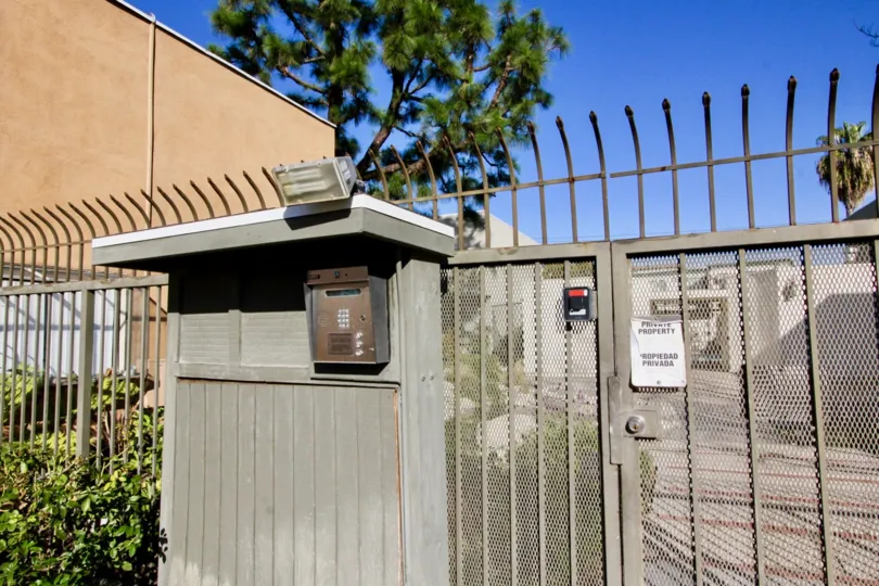 Meshed entry gate with high security fence and adjacent resident intercom box with spotlight in Pine Creek