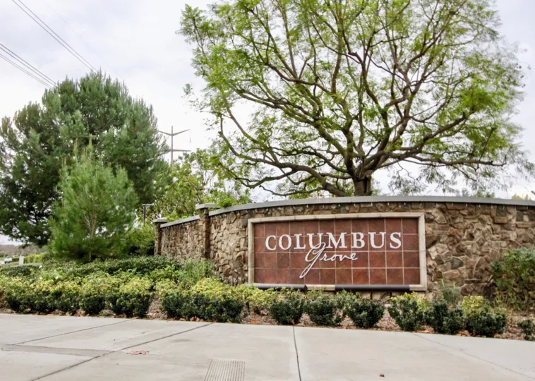 Decorative community name sign with smartly trimmed shrubs and cobblestone wall in Ainsley Park