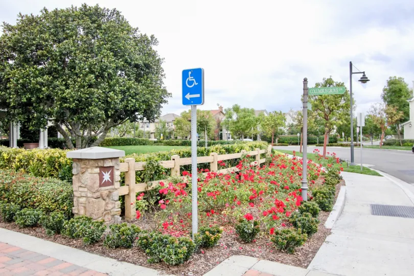 A blue handicapped parking sign sits in a garden patch in the Ainsley Park community