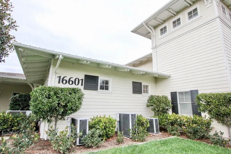 Large white home in Ainsley Park with landscaping, well-kept lawn.