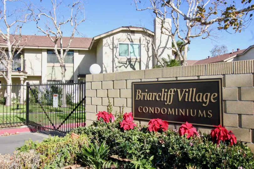 This image shows the entrance way to the beautiful house that titled in the name of Briarcliff Village which has the beautiful plants with flowers in the front side