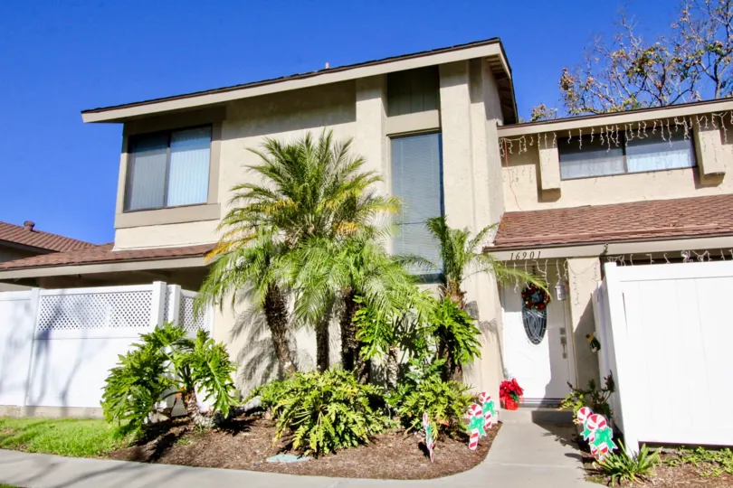 Beautiful home on a bright day with a blue sky in the community of Briarcliff Village in Tustin, California with palm trees!