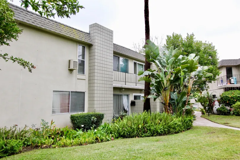 A Beautiful Big House, Small Garden Containing Few Trees, little grass.