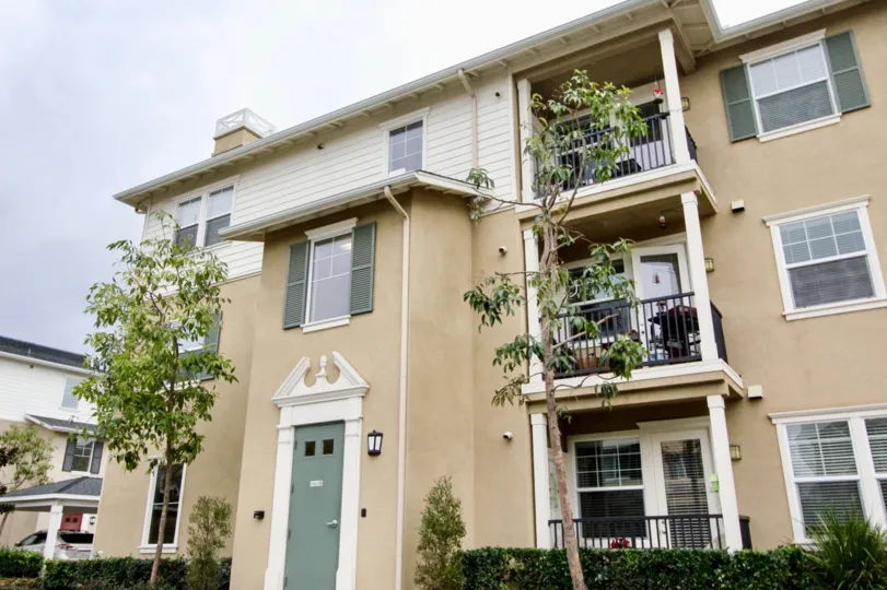 A three-storey townhouse with corner balconies in the Cambridge Lane community.