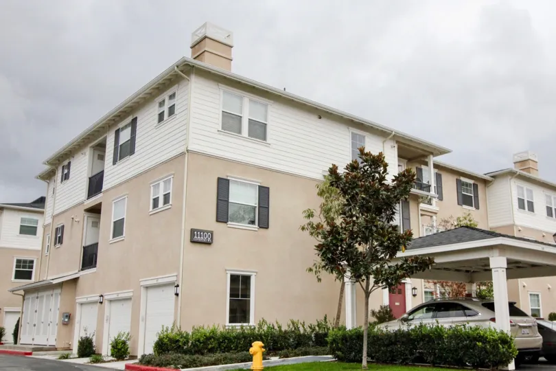 This views the beautiful side view of the house which the trees and the plants and also have the car with parking in the city of Tustin