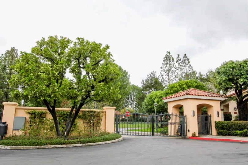 A black gate secures the driveway entrance to the Corte Villa community